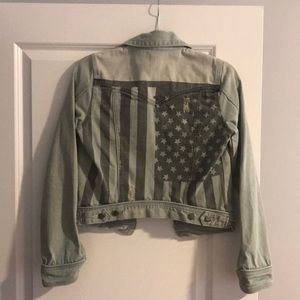 Distressed denim jacket with American flag on back